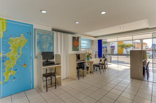 una habitación con un mapa en la pared y una mesa con sillas en Marazul Apart Hotel, en Florianópolis