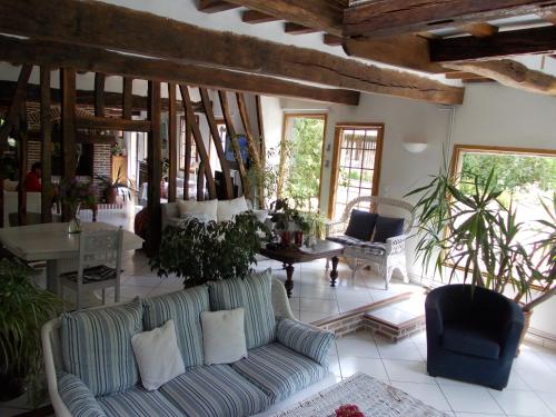 a living room with a couch and a table at Le Moulin des Roses in Neslette