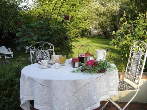 a table with a white table cloth and flowers on it at Le Moulin des Roses in Neslette