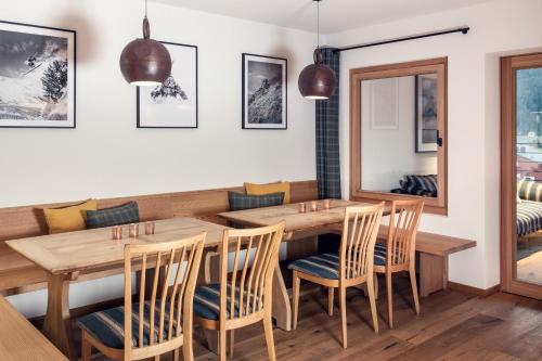 a dining room with a wooden table and chairs at Conrad's Mountain Lodge in Silvaplana