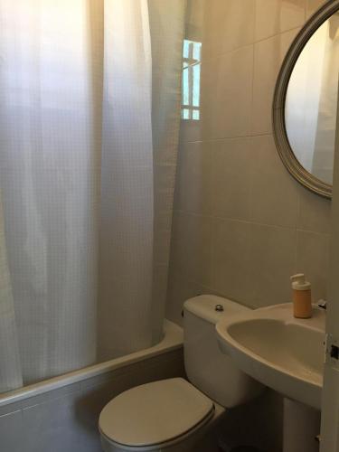a white bathroom with a toilet and a sink at Las Olivas in Candeleda