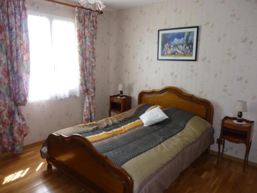 a bedroom with a bed in a room with a window at La maison des Bruyères in Orbigny