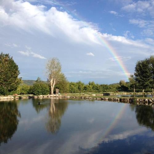 a rainbow in the sky over a large lake at La Fontanella in Montecchia di Crosara
