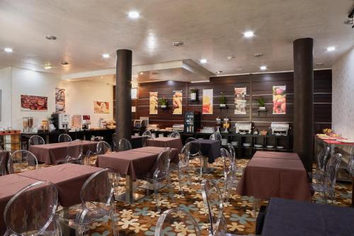 a restaurant with tables and chairs in a room at Hotel Granda in Cangas de Onís