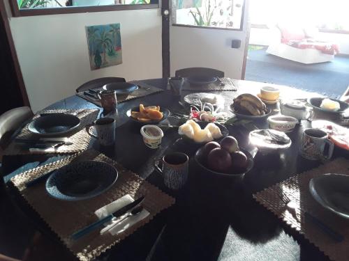 法赫的住宿－Tifaifai Et Café Huahine，桌上放有盘子和碗的食物