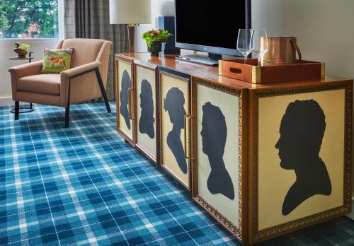 a living room with a dresser with a tv on top at Graduate by Hilton Charlottesville in Charlottesville