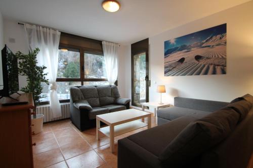 ein Wohnzimmer mit einem Sofa und einem Stuhl in der Unterkunft Pont de Toneta 1,1 Ransol, Zona Grandvalira in Ransol