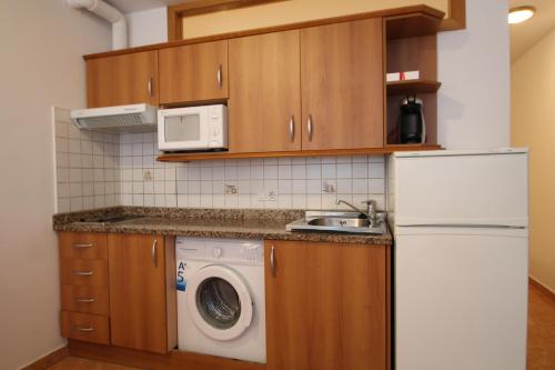 eine Küche mit einem weißen Kühlschrank und einer Waschmaschine in der Unterkunft Pont de Toneta 1,1 Ransol, Zona Grandvalira in Ransol