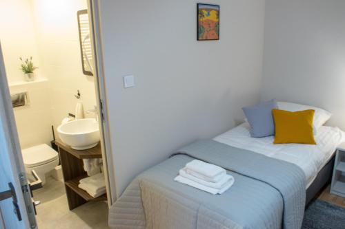 ein kleines Schlafzimmer mit einem Bett und einem Waschbecken in der Unterkunft Podomek in Kielce
