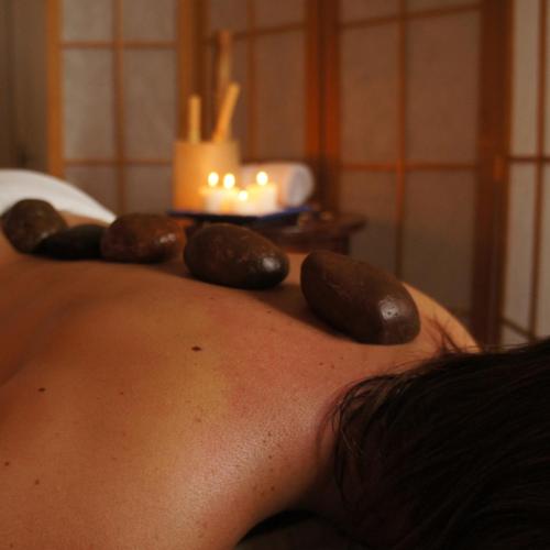 a woman with rocks on her back with a candle at Argentino Hotel Casino & Resort in Piriápolis