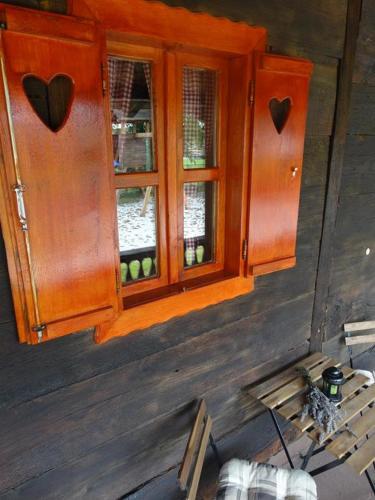 a window in a wooden house with a bench at Pod orehom drvena kuća i sauna in Krapina
