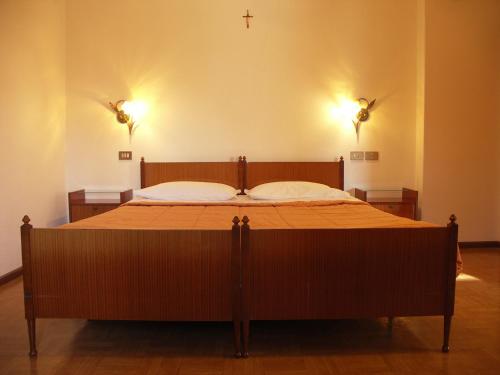 a large bed in a room with two lights at Villa Erika in Sappada