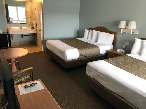 a hotel room with two beds and a table at Surfside Motel in Point Pleasant Beach