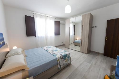 een slaapkamer met een bed en een spiegel bij Iori Salento B&B in San Pancrazio Salentino