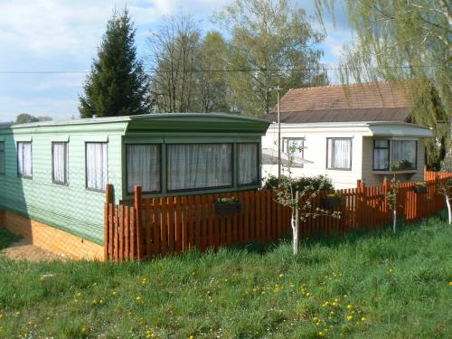 ein kleines Haus mit einem Zaun im Hof in der Unterkunft Ubytovani Fanisek v mobilnim domku v ceskem raji in Sobotka