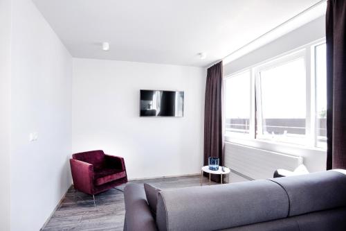 a living room with a couch and a chair and a window at Svala Apartments by Heimaleiga in Reykjavík