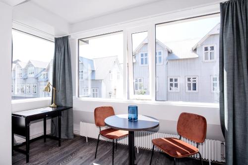 een woonkamer met een tafel en stoelen en een raam bij Svala Apartments by Heimaleiga in Reykjavík