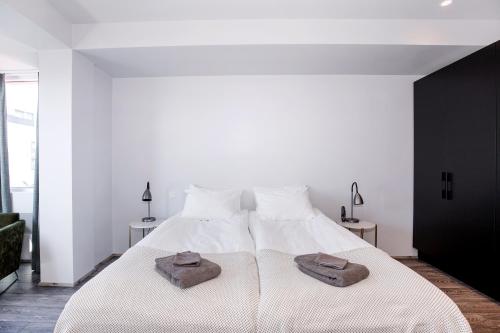 a bedroom with a white bed with two towels on it at Svala Apartments by Heimaleiga in Reykjavík