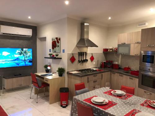 a kitchen with a table and a tv in it at Marsascala Sea View Apartment & Penthouse in Marsaskala