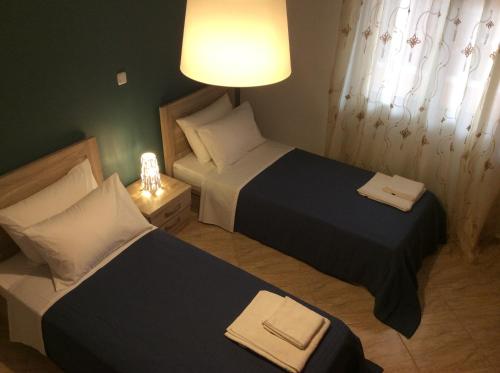 Duas camas num pequeno quarto com um candeeiro em xanthippi em Varvásion