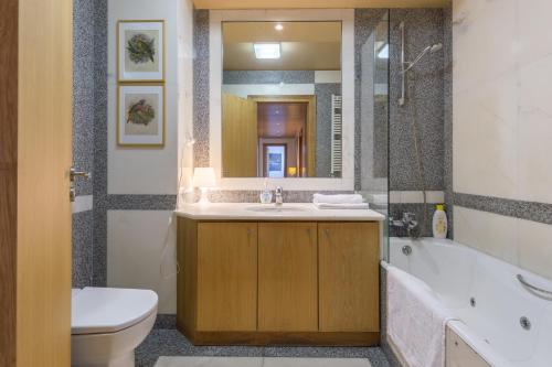łazienka z umywalką, wanną i toaletą w obiekcie Deluxe Condominium with Ocean View w Porto