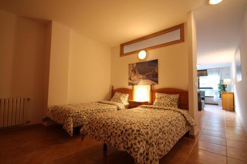 1 dormitorio con 2 camas y lámpara en Pont de Toneta 1,6 Ransol, Zona Grandvalira, en Ransol