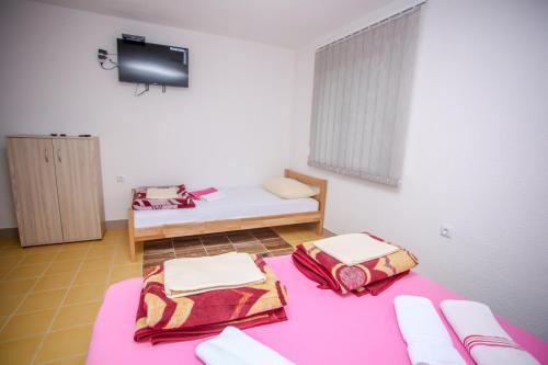 Habitación pequeña con 2 camas y TV. en Apartments River 1, en Bihać
