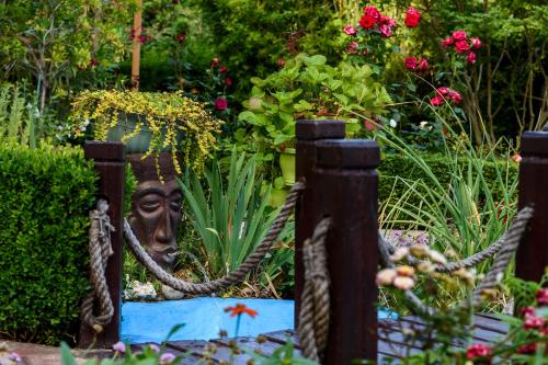 a garden with a statue of a head behind a fence at Vila Saltanat 41 in Varna City