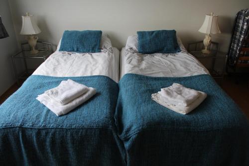 two beds sitting next to each other with towels on them at Fosstún Guesthouse in Skogar