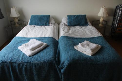 2 letti posti uno accanto all'altro con asciugamani di Fosstún Guesthouse a Skogar