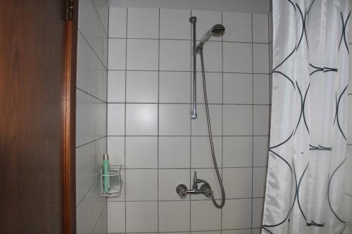 a shower with a shower head in a bathroom at Fosstún Guesthouse in Skogar