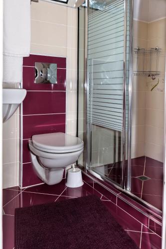 a bathroom with a toilet and a glass shower at Vila Saltanat 41 in Varna City