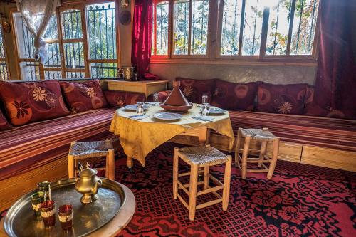 a living room with a table and a couch at Gite Tamlli in Aoufous