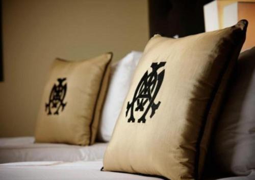 two pillows with chinese writing on them on a bed at The Mayo Hotel in Tulsa