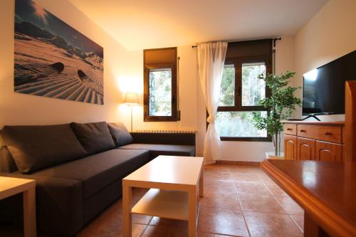 sala de estar con sofá y mesa en Pont de Toneta 2,2 Ransol, Zona Grandvalira en Ransol