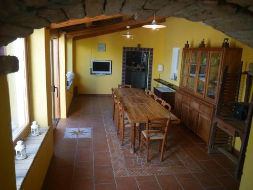 a dining room with a long wooden table and chairs at B&B Sa Tuerra in Teulada