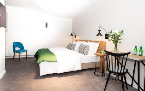 a bedroom with a bed and a desk and chairs at poznańska19 in Nowy Tomyśl