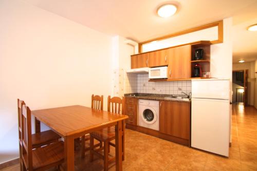 uma cozinha e sala de jantar com uma mesa e um frigorífico em Pont de Toneta 2,3 Ransol, Zona Grandvalira em Ransol