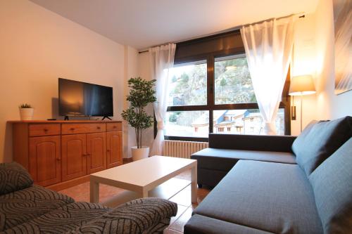 a living room with a couch and a tv at Pont de Toneta 2,3 Ransol, Zona Grandvalira in Ransol