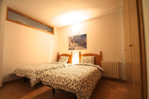 1 dormitorio con 2 camas y una foto en la pared en Pont de Toneta 2,3 Ransol, Zona Grandvalira, en Ransol