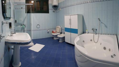 y baño con bañera, lavabo y aseo. en Villa Meminaj, en Vlorë