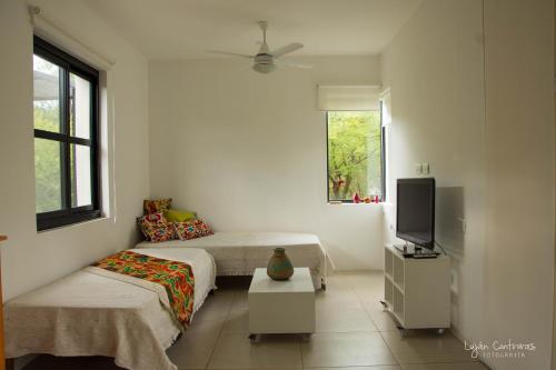 a white room with two beds and a tv at Casas del Champaquí in San Javier