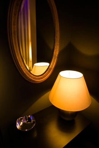 a lamp sitting on a table in front of a mirror at Ivana Hotel in Oradea