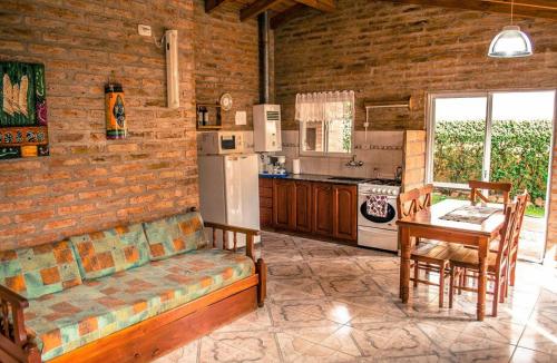 a kitchen with a couch and a table and a refrigerator at Cabañas Don Mario in Sierra de la Ventana