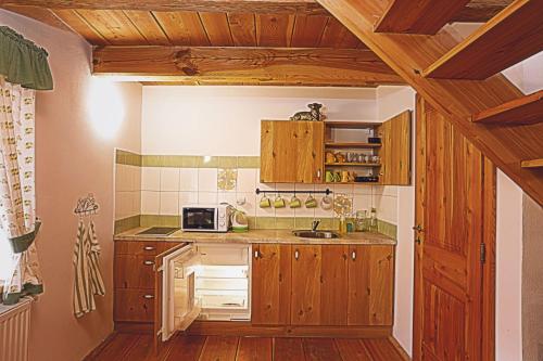a kitchen with wooden cabinets and a sink at U Svatého Petra in Kájov