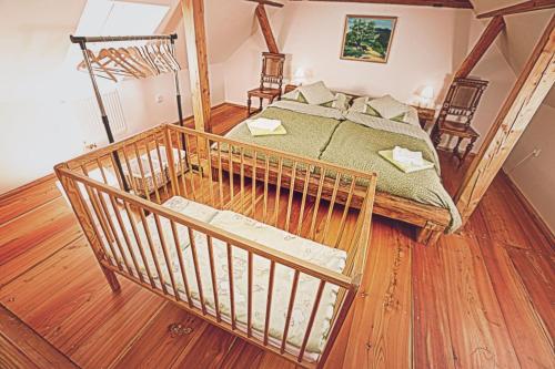 duże łóżko w pokoju z drewnianą podłogą w obiekcie U Svatého Petra w mieście Kájov