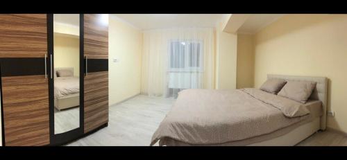 a bedroom with a bed and a large mirror at Mega city in Kyiv