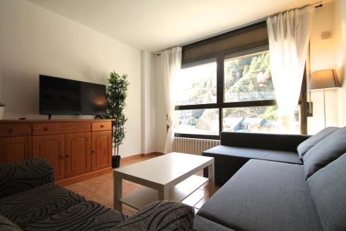 a living room with a couch and a tv at Pont de Toneta 3,3 Ransol, Zona Grandvalira in Ransol