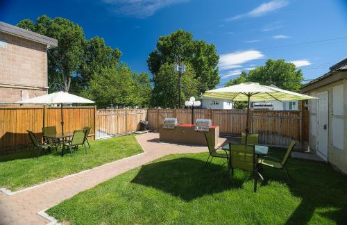 a patio with a table and chairs and an umbrella at Tiki Shores Inn & Suites in Penticton