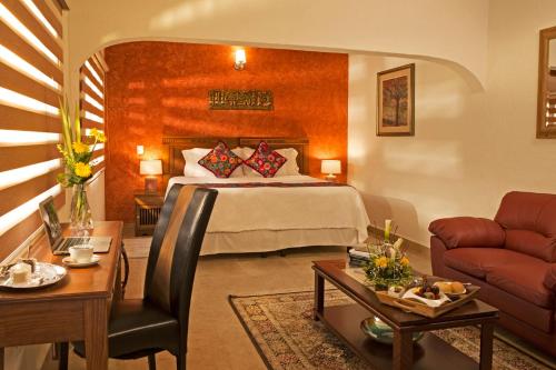 a hotel room with a bed and a living room at La Buena Vibra Retreat and Spa Hotel in Tepoztlán